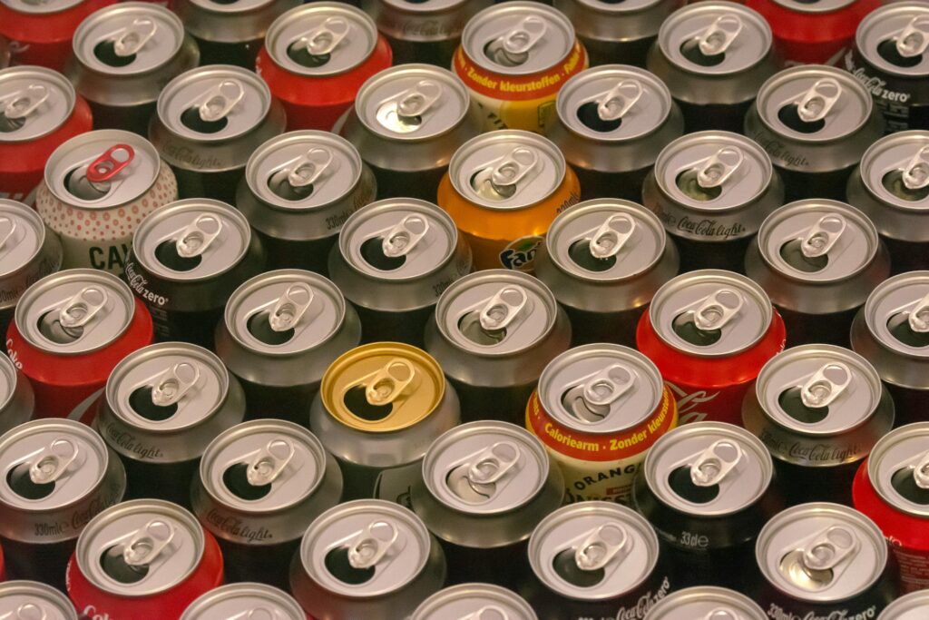 pexels-photo-19354737-19354737 Top view of various aluminum soda cans lined up in colorful rows, highlighting recycle potential.